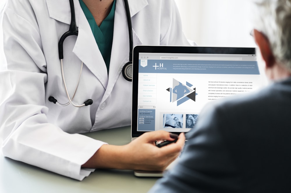 doctor showing laptop image on a person in black top