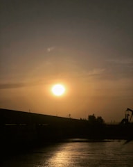 Sunset over a bustling oil field with active machinery.