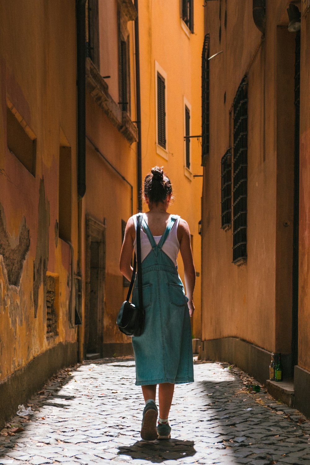 Frau im Kleid, die auf der Gasse spazieren geht