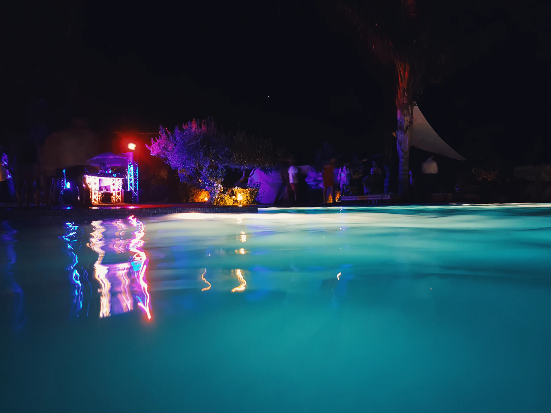 A swimming pool glowing blue at night
