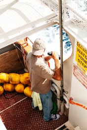 man holding black binocular standing beside yellow water buoy