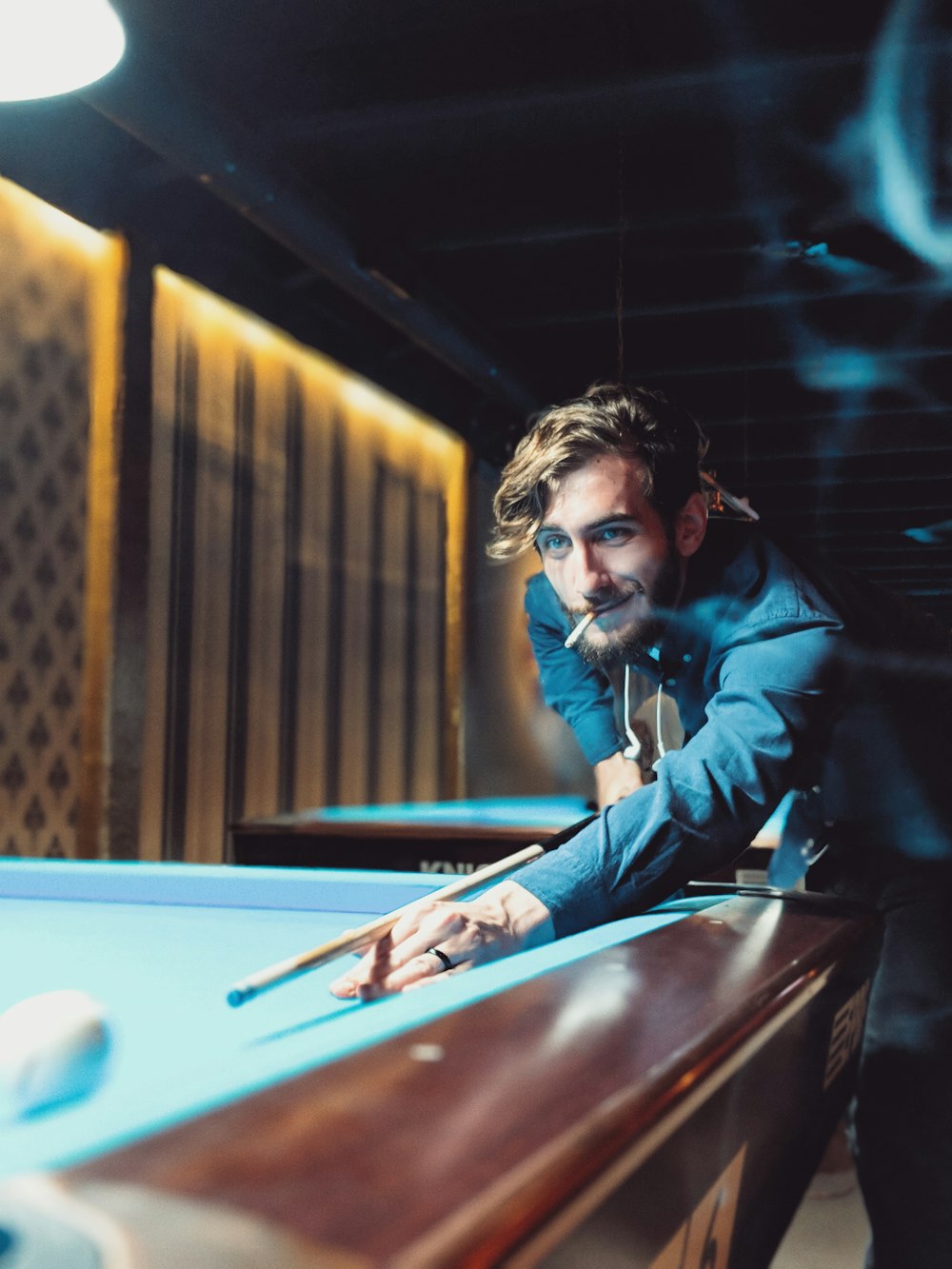 man smoking white playing billiard