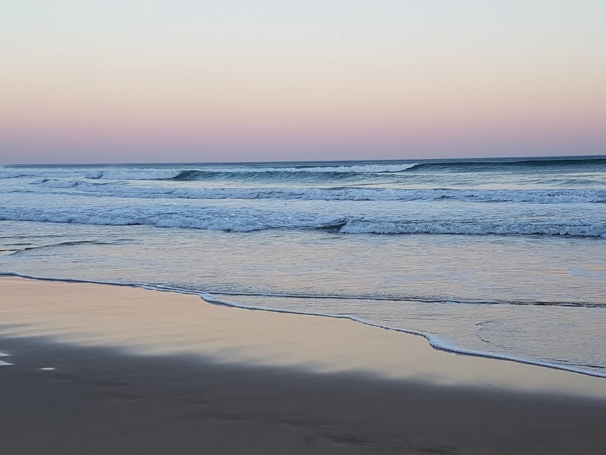 Waves running up the sand at Wilderness at dusk