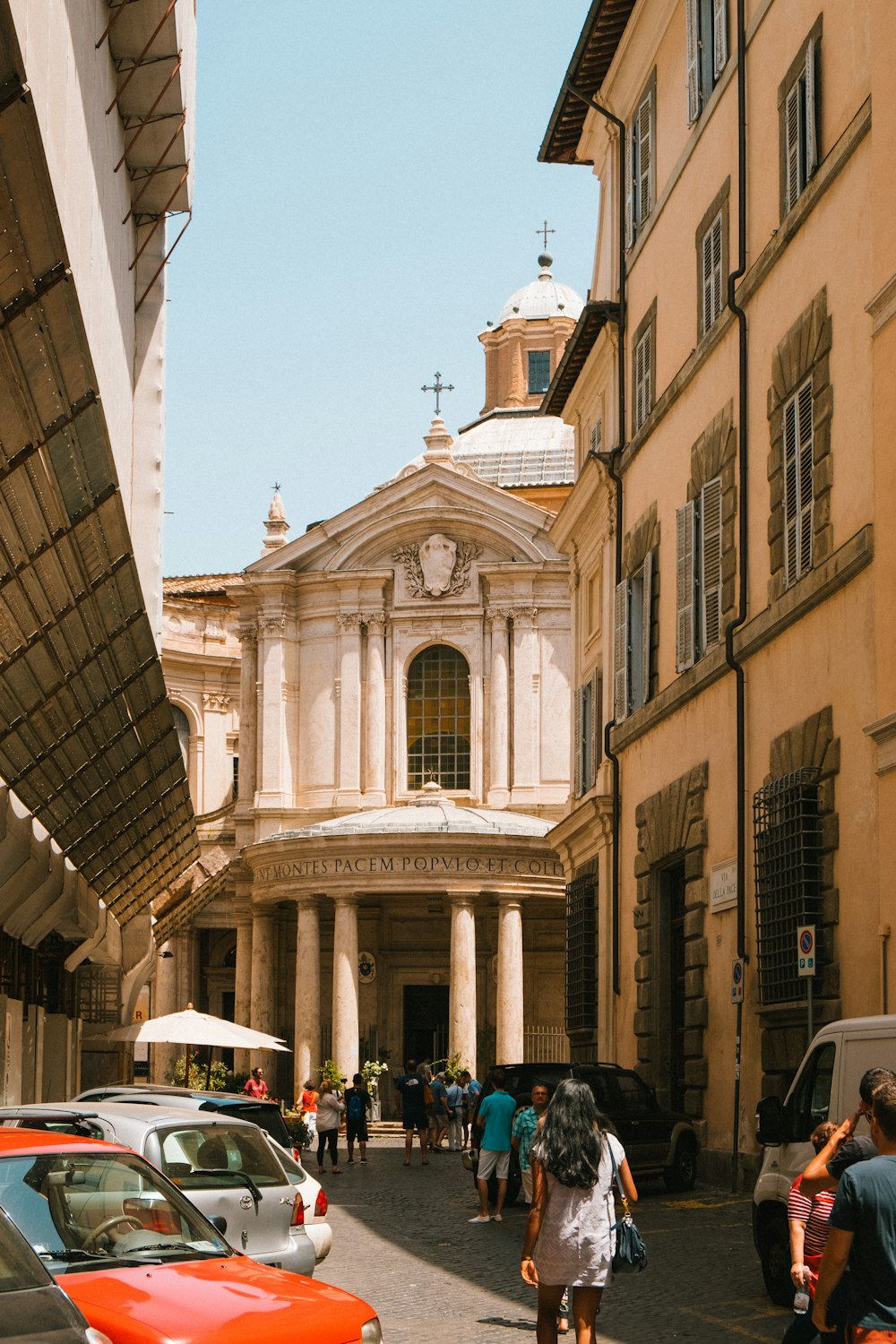 Persone che camminano vicino alla cattedrale di cemento bianco durante il giorno