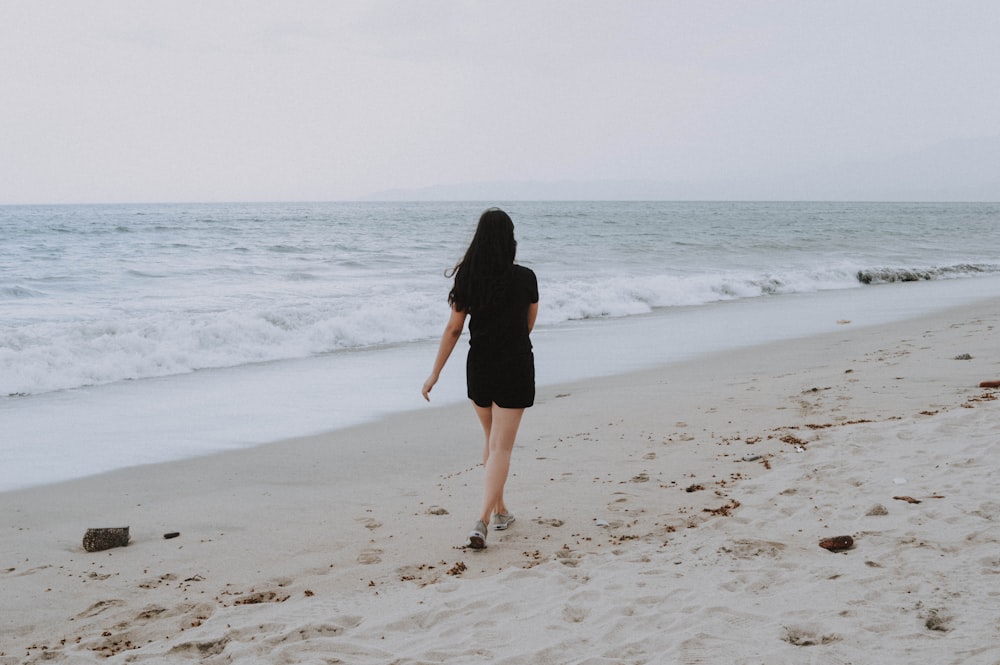 mujer caminando en la orilla de la playa