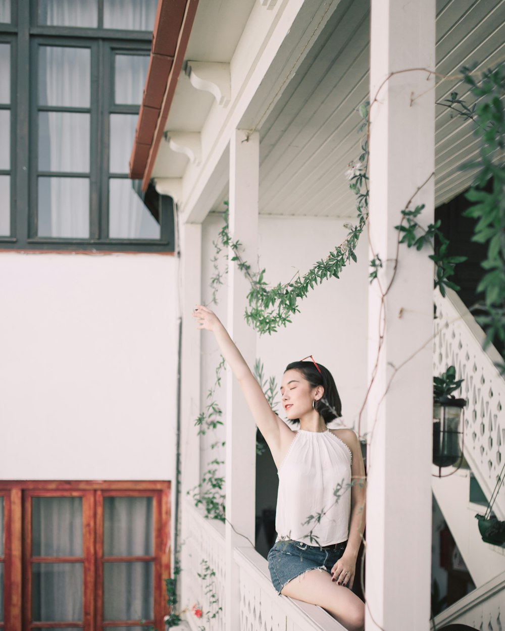 woman sitting on stair while raising right hand