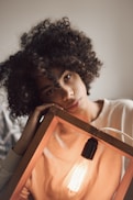 woman holding brown wooden framed light bulb