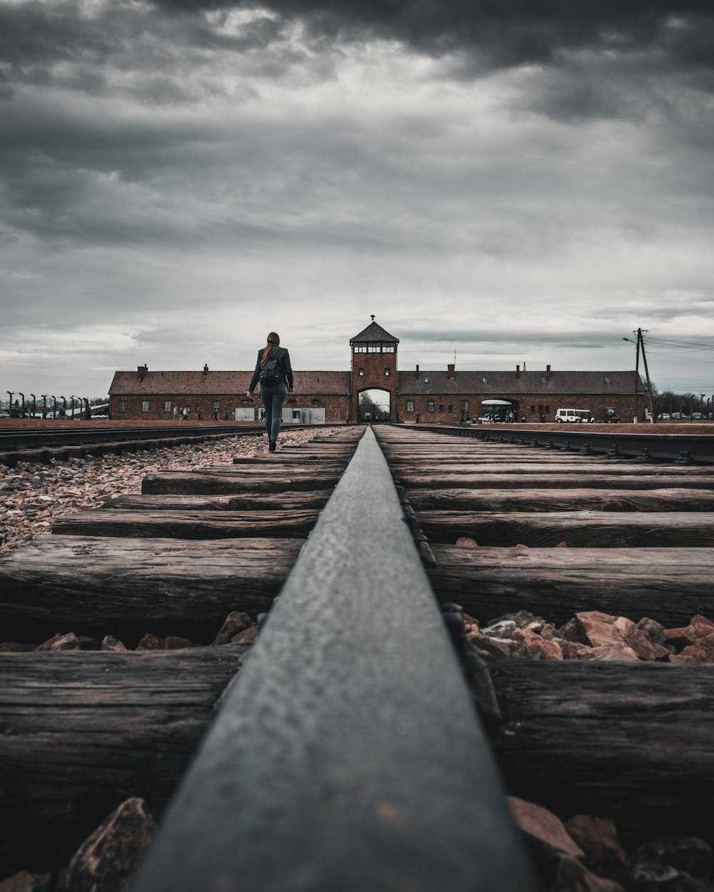 person walking on train tracks during daytime