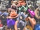 A collection of colorful hats displayed on stands, featuring a variety of styles including fedoras. Each hat has a price tag with handwritten numbers attached to the brim. The hats are in shades of orange, purple, red, green, and more, showcasing a vibrant assortment.