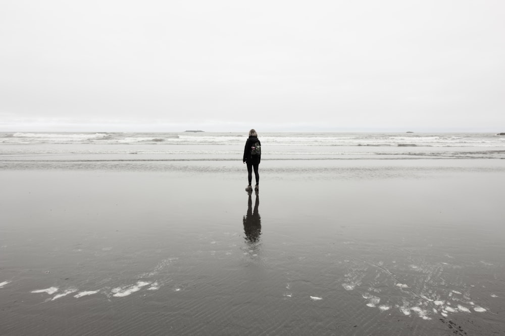persona in piedi vicino al mare durante il giorno