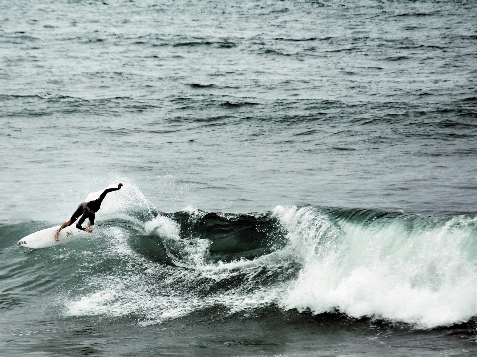 Canon EOS 550D (EOS Rebel T2i / EOS Kiss X4) + Canon EF-S 18-200mm F3.5-5.6 IS sample photo. Person surfboarding on waves photography