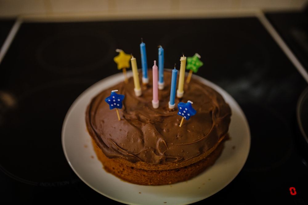 baked cake with candles on white plate