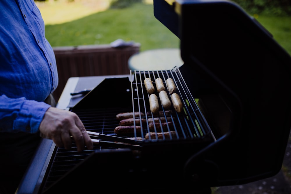 Mann grillt tagsüber Wurst