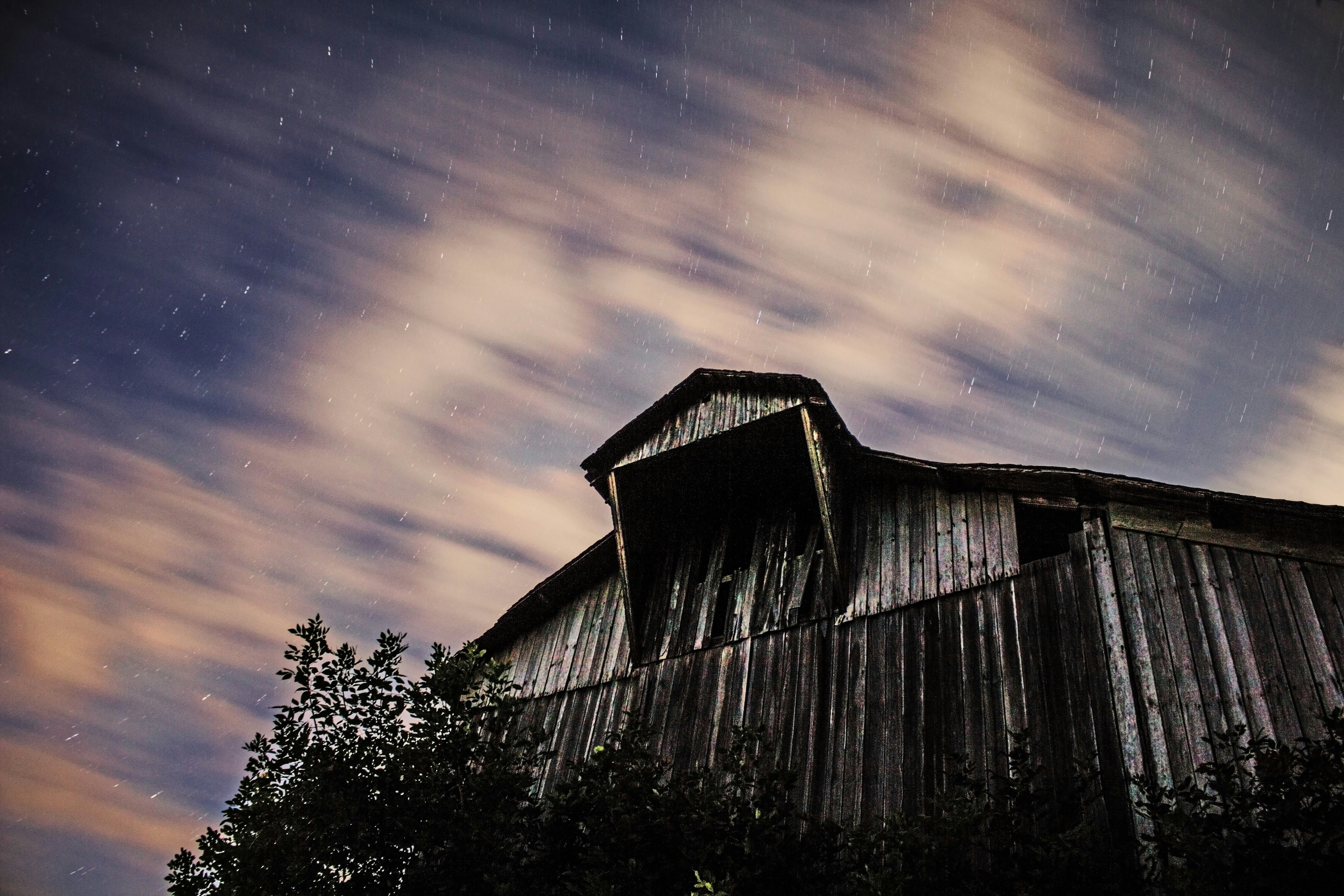 low-angle photography of wooden barn under cloudy sky