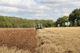 green tractor farming in field