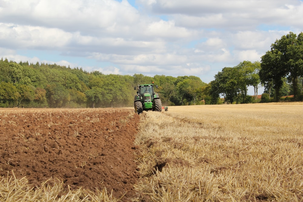 green tractor farming in field