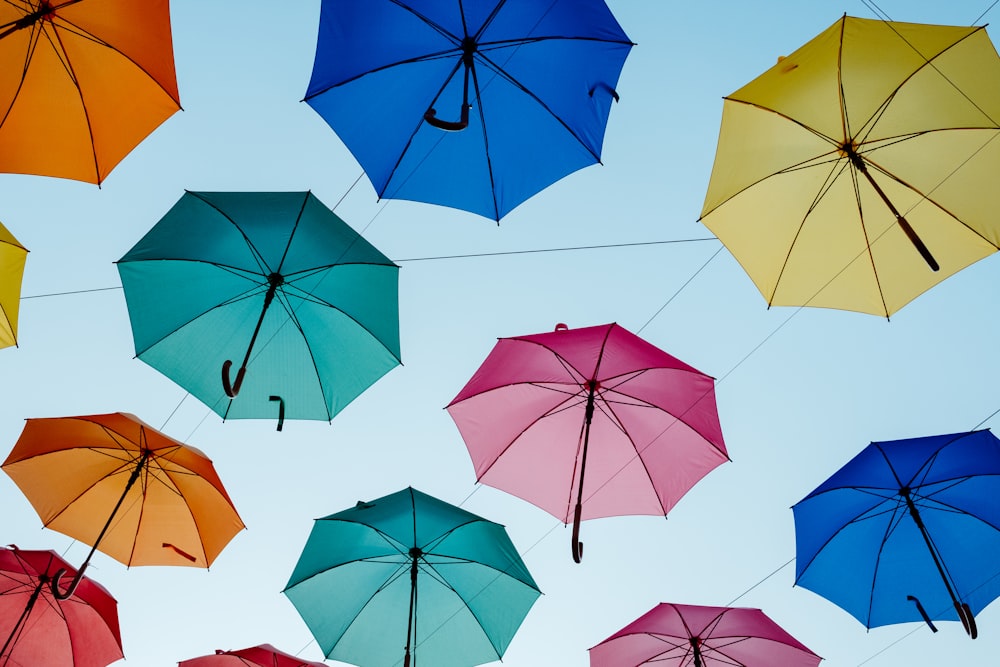 verschiedenfarbiger Regenschirm an grauen Drähten hängend
