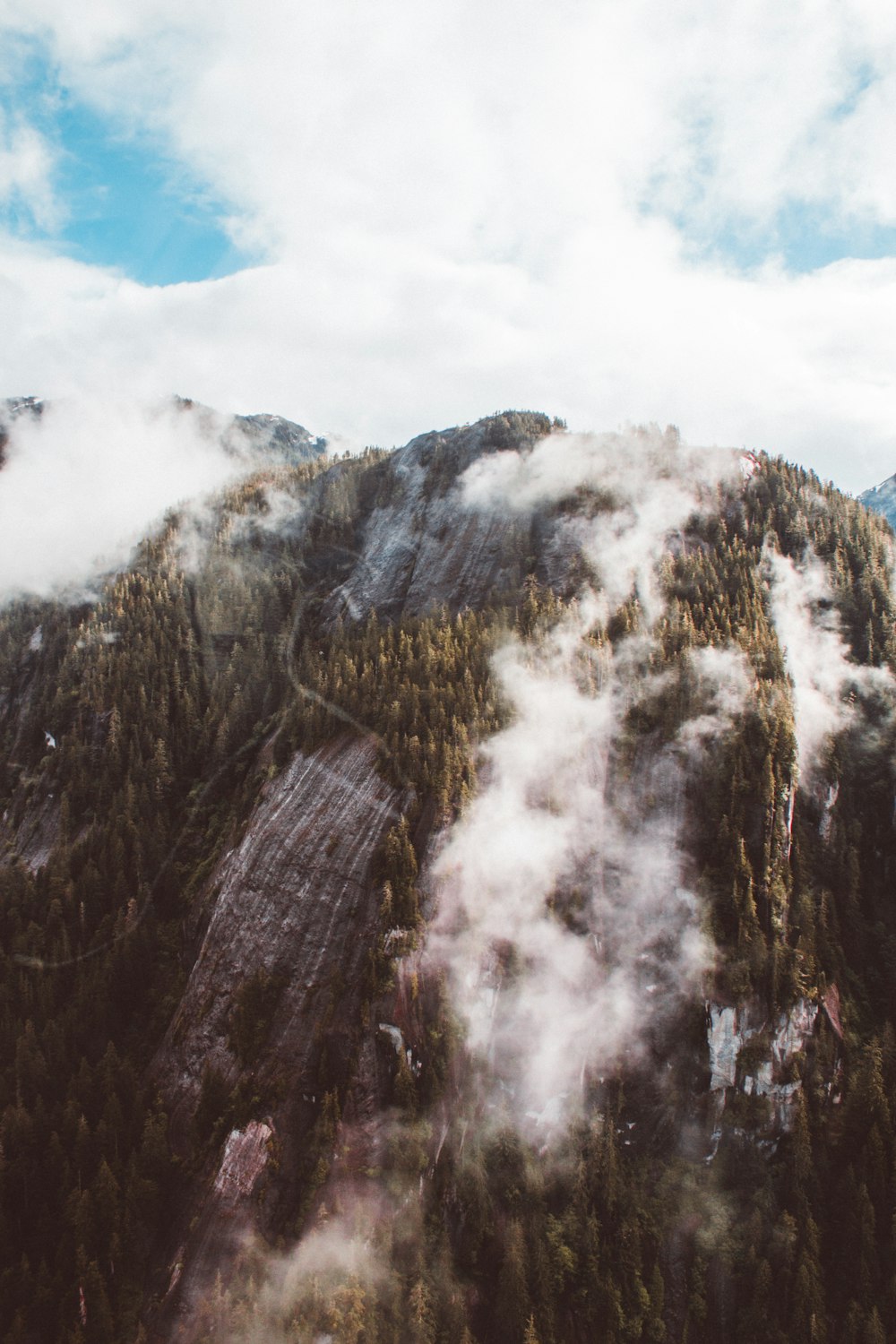 mountain view with fog under cloudy sky at daytime