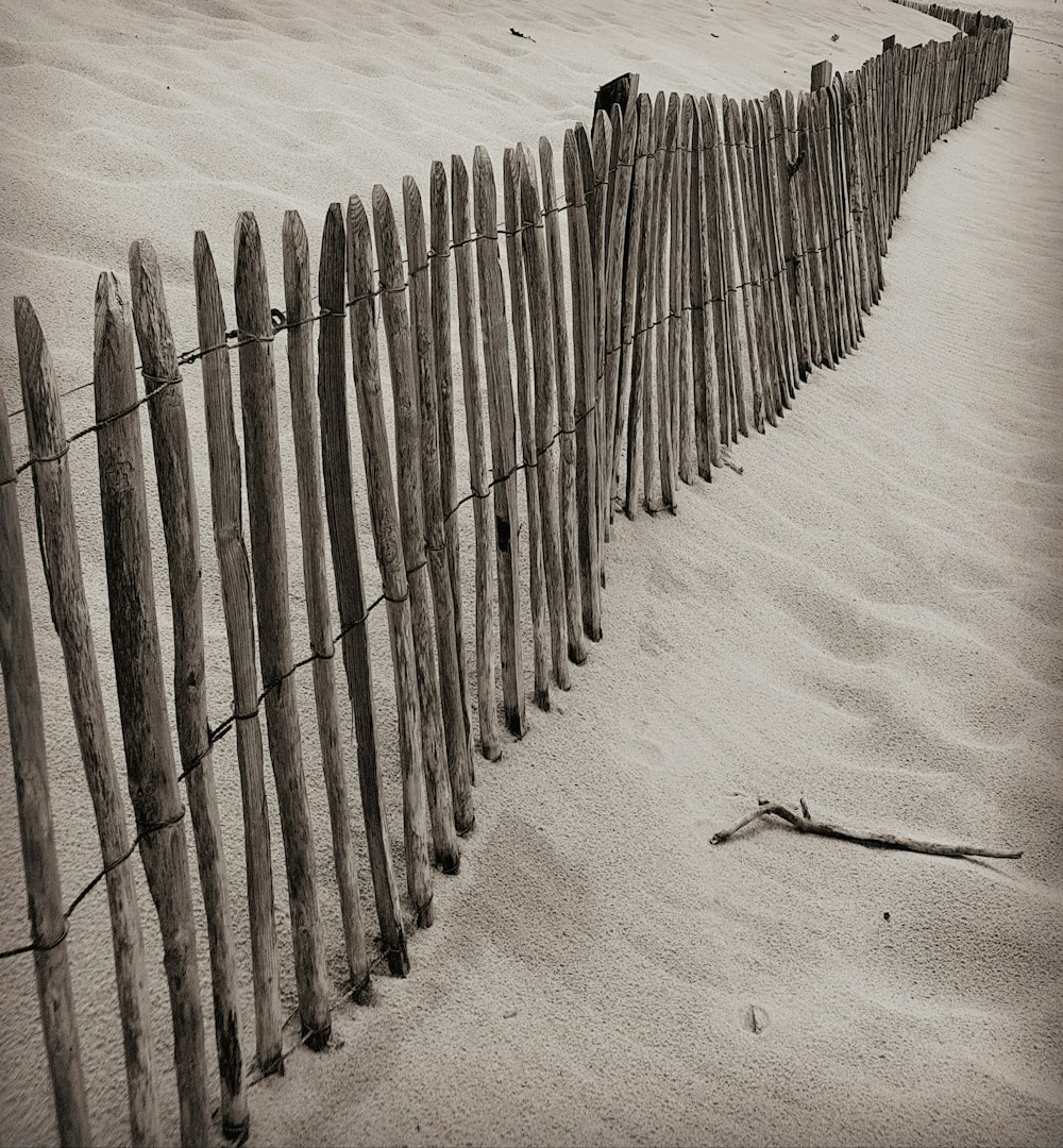 valla de madera gris sobre arena