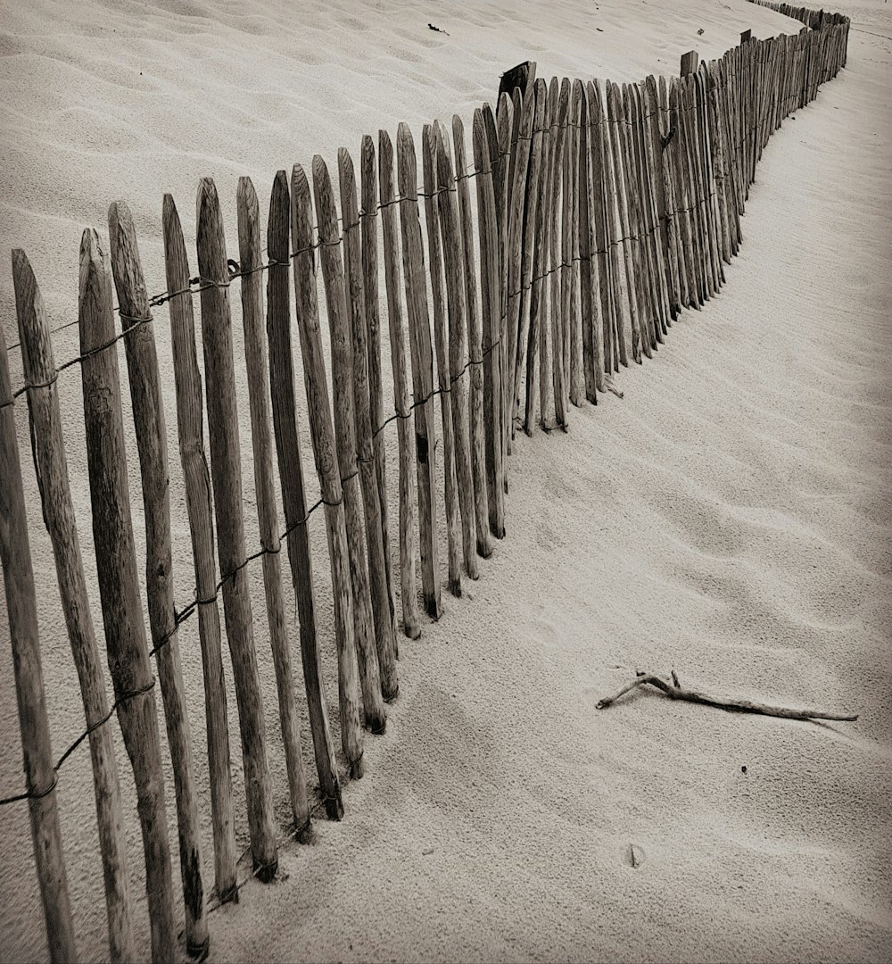 gray wood fence on sand