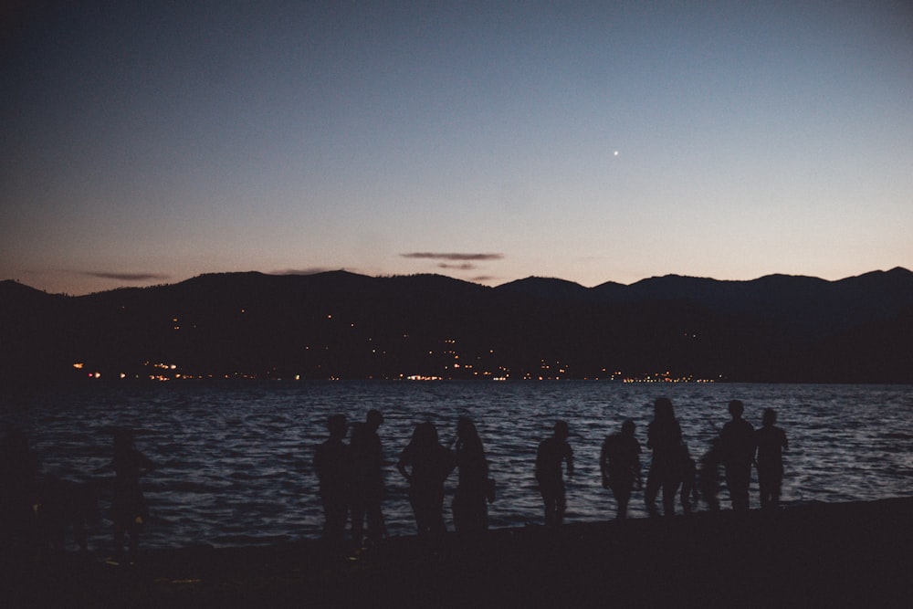 silhouette of people on beach during golden hour