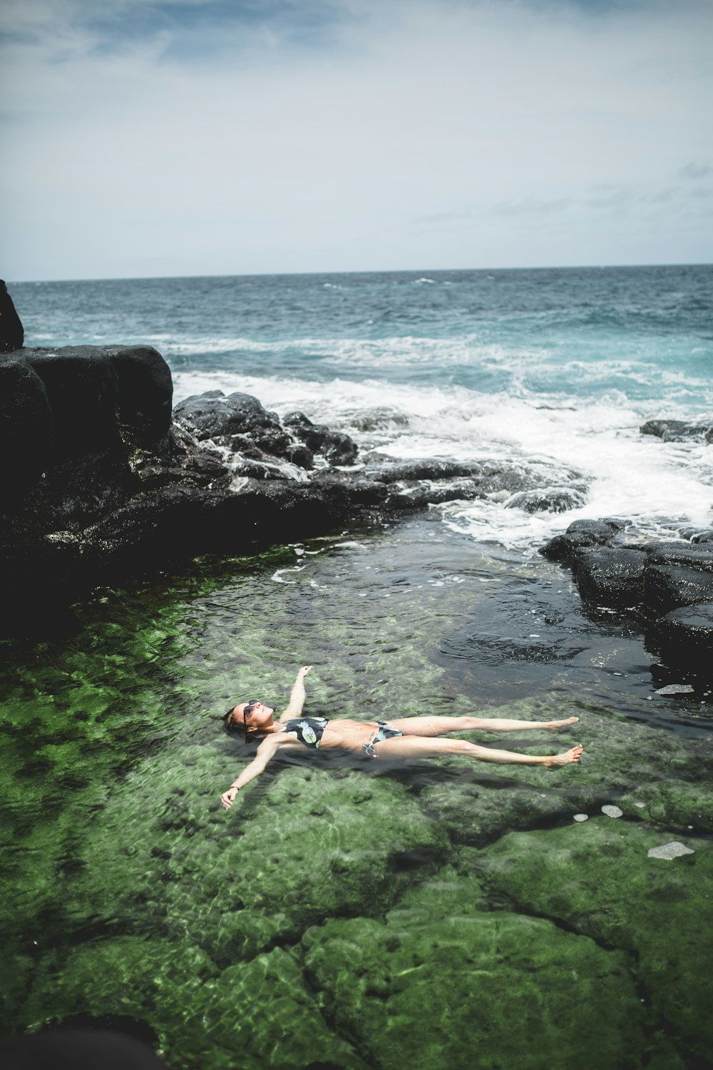 woman floating on body of water during daytime