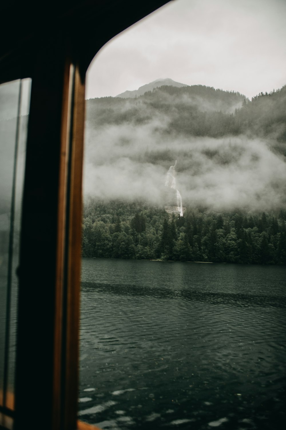 foggy green mountain near lake