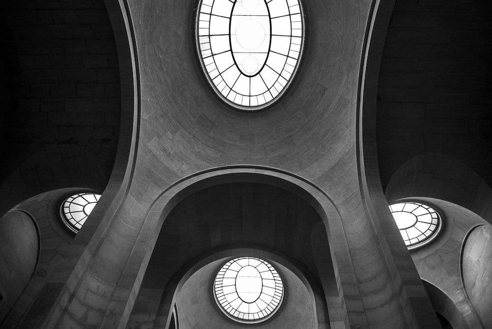 interior building with glass window at the roof grayscale photography