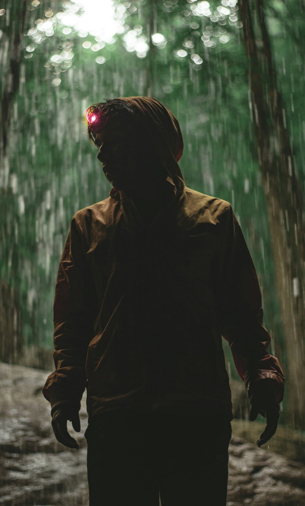 person wearing headlamp standing beside trees