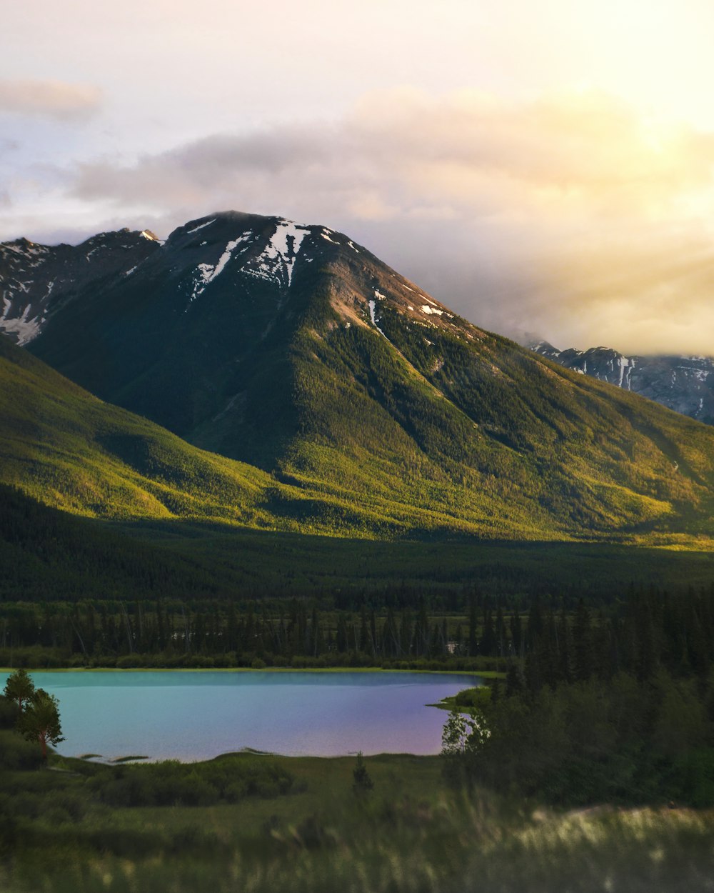 green grassy mountain near lake