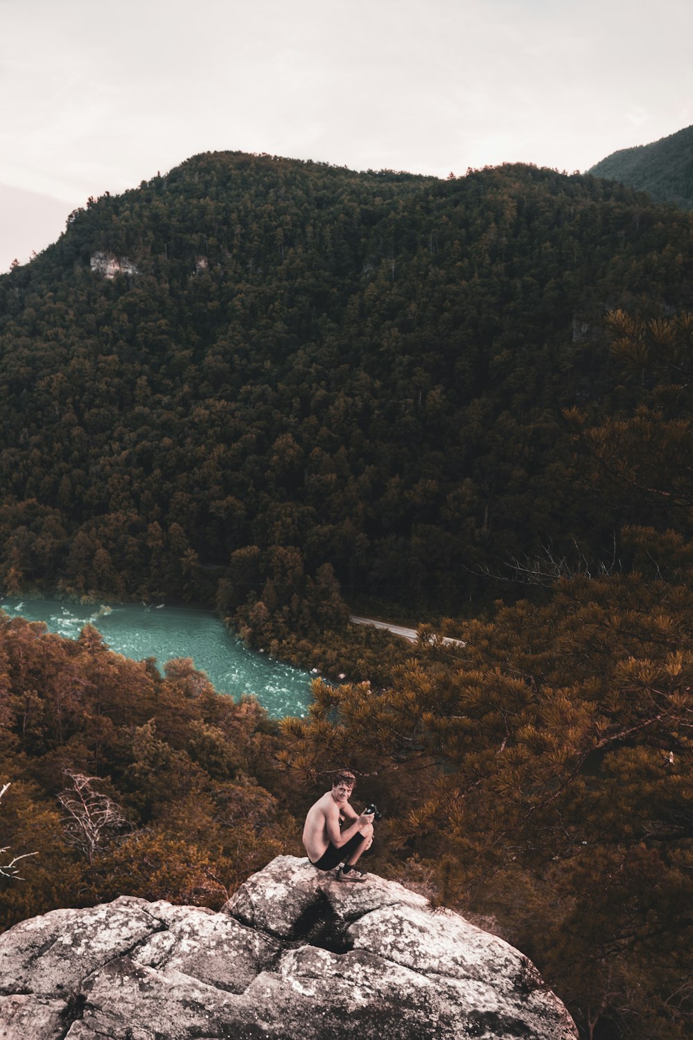 photo of man sitting on rock formation