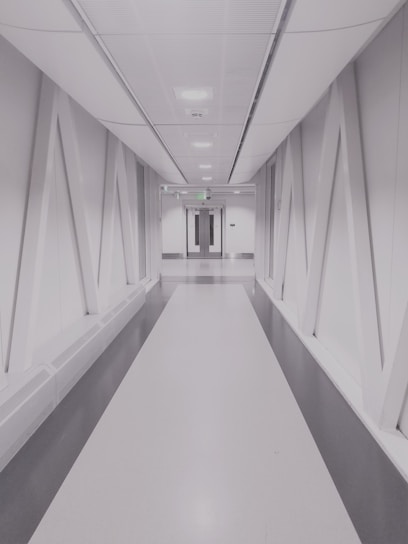 person taking photo of white and gray hallway