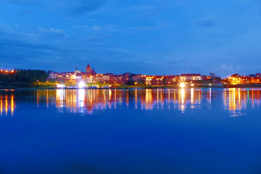 body of water with buildings on shore under blue sky