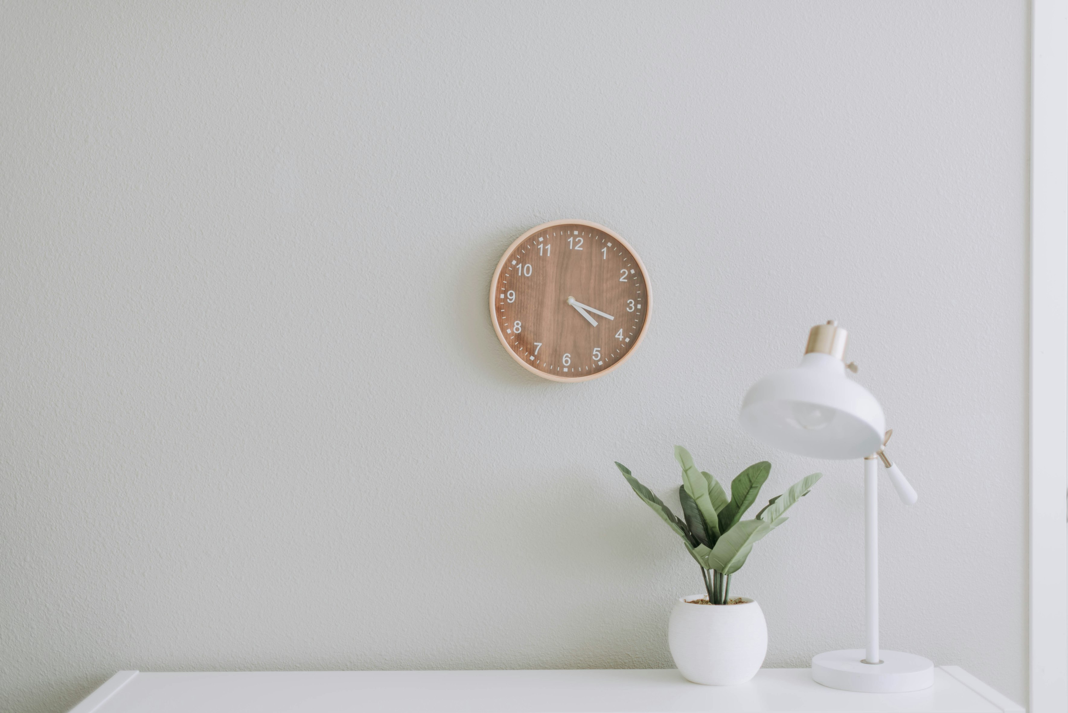 Plain white wall with clock on the wall.