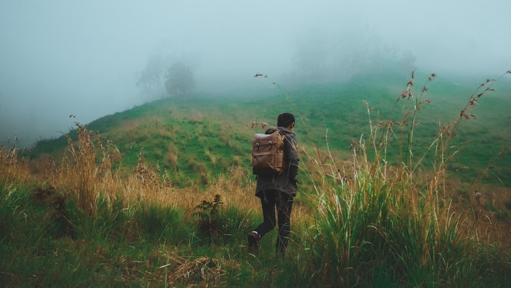 a person with a backpack walking up a hill