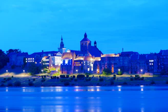 A serene view of Prague's historic skyline at sunset, highlighting the castle and Charles Bridge.
