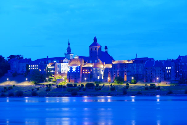 A serene view of Prague's historic skyline at sunset, highlighting the castle and Charles Bridge.