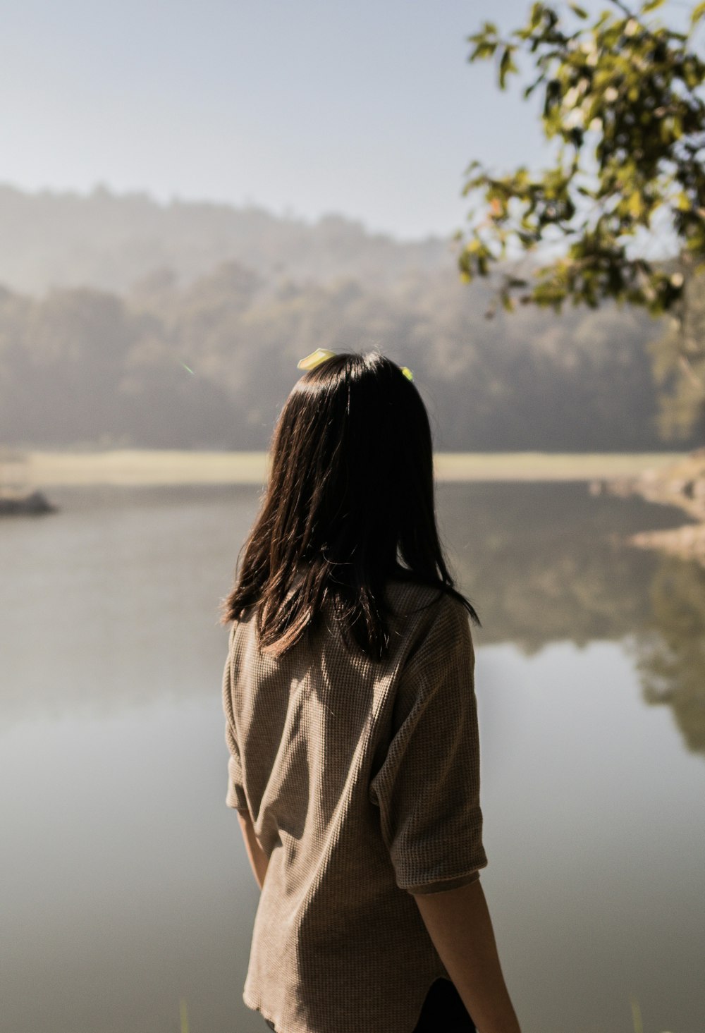 photo of woman back standing near body of water