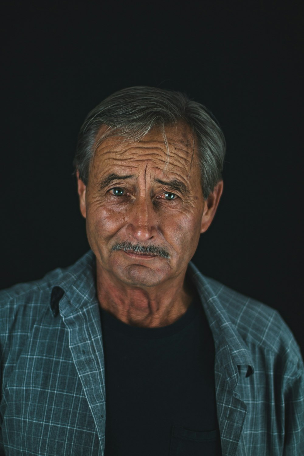 Photographie en basse lumière d’un homme portant une chemise à col bleu