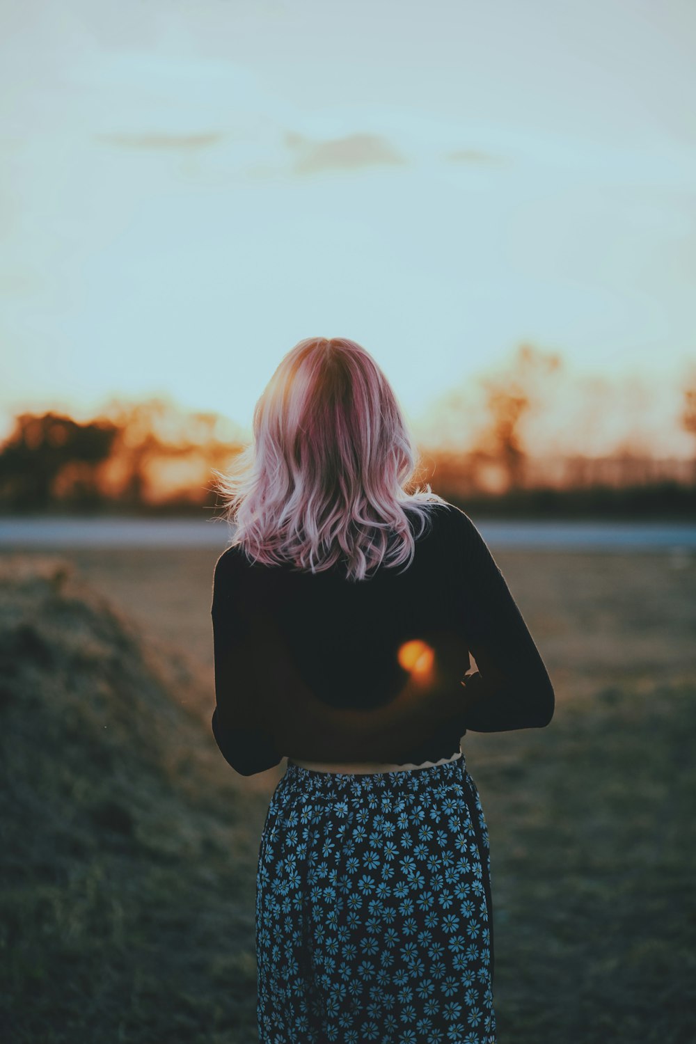 woman standing facing body of water