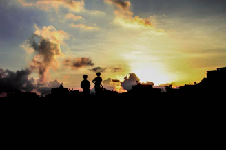 A cinematic shot of Bruce and Gaynor silhouetted against the Johannesburg skyline at dusk.