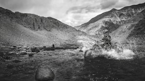Smiling rider crossing a shallow stream with splashing water around the ATV tires