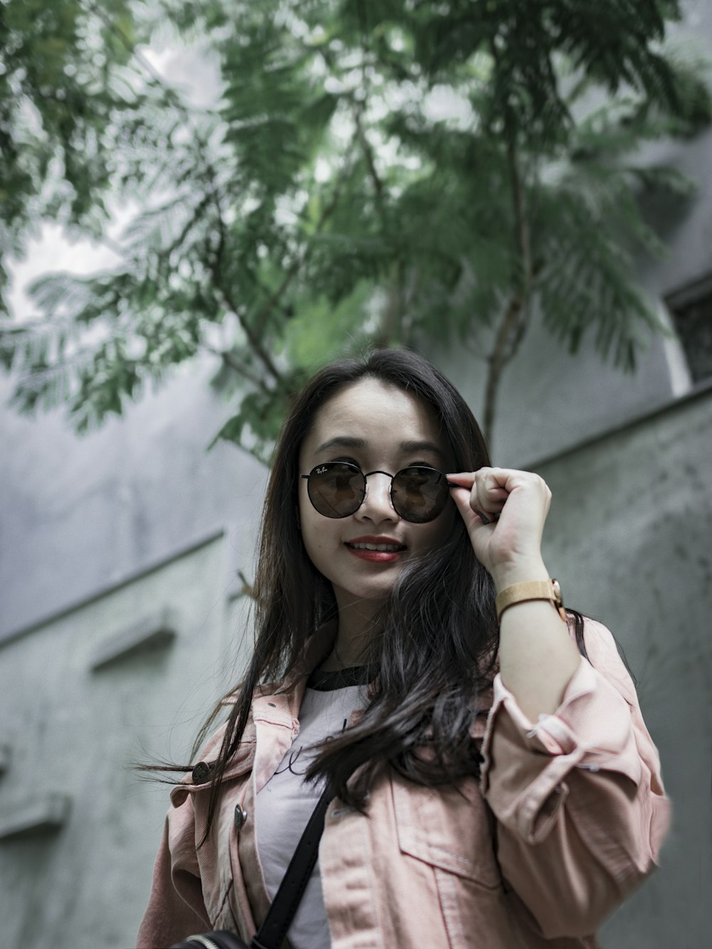 woman wearing pink jacket holding glass posing