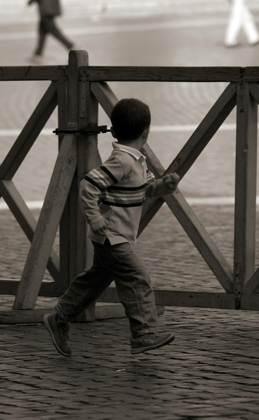 boy running beside fence