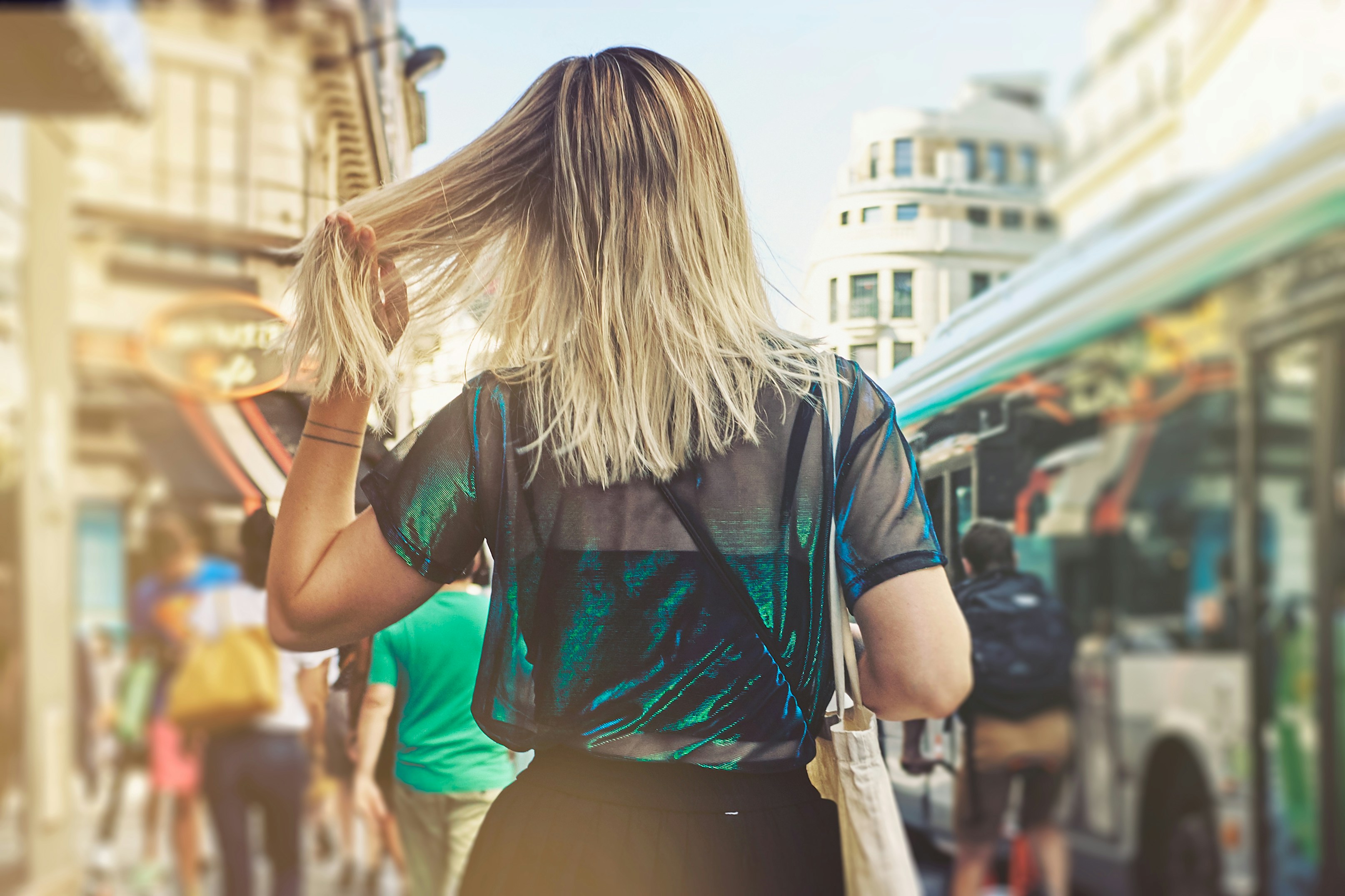 selective focus photography of woman waving her hair on crowded place