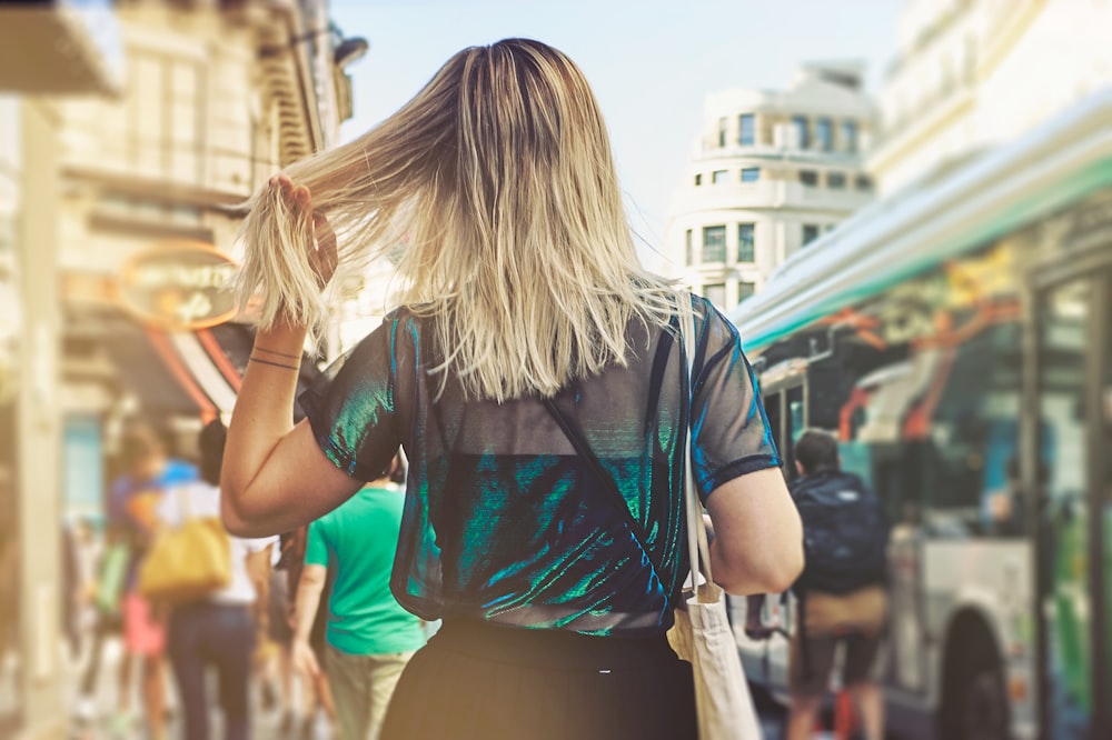 selective focus photography of woman waving her hair on crowded place