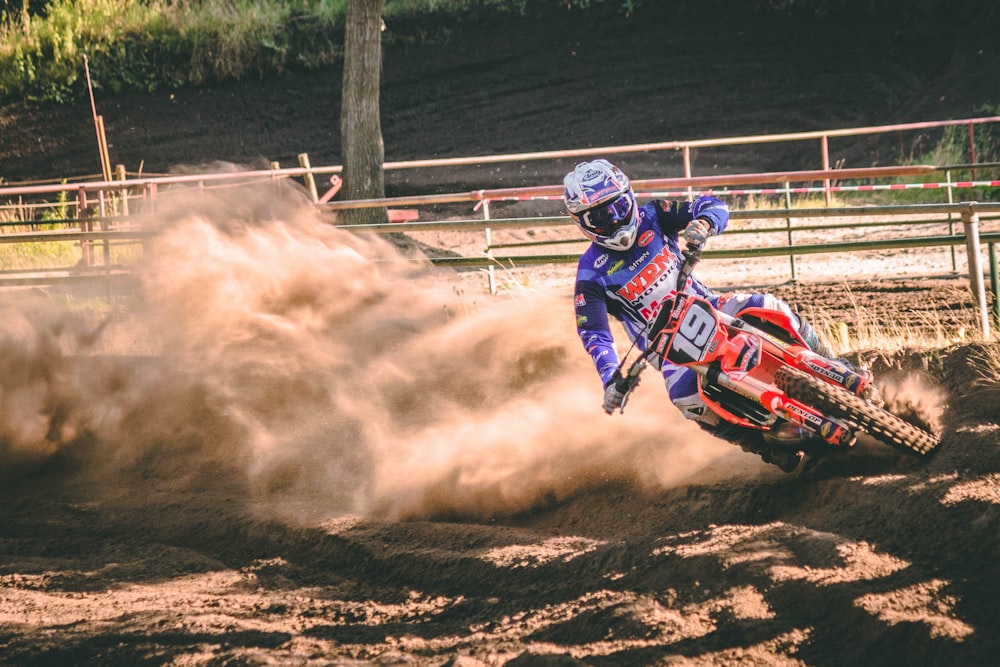 person riding on motocross dirt bike drifts on race track