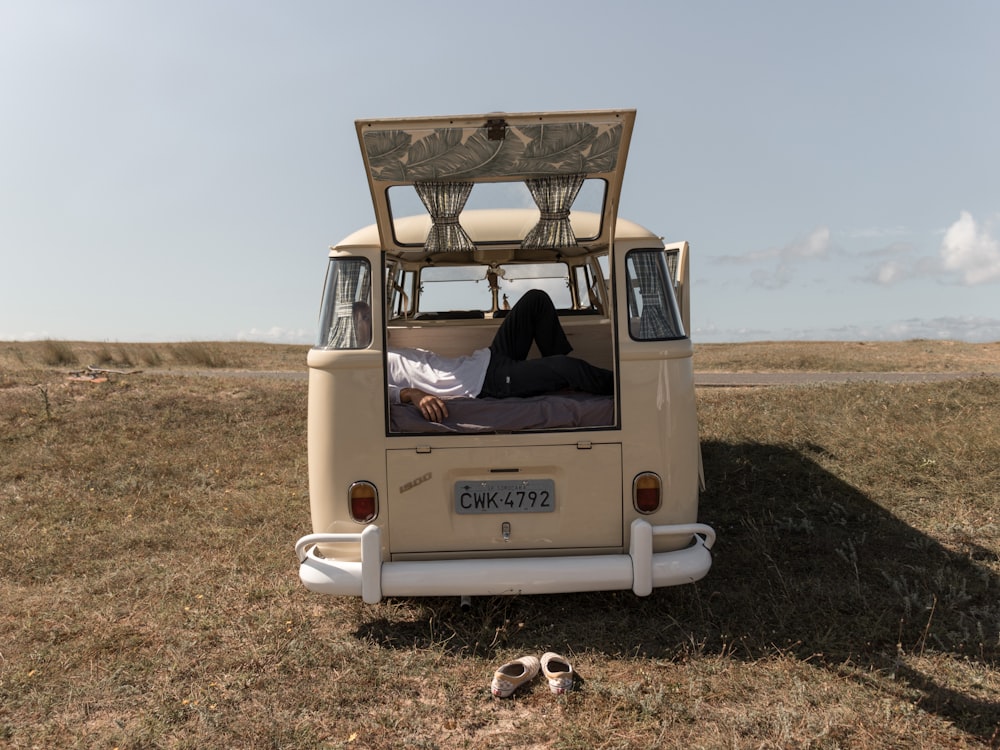 beige minivan parked in green grass field