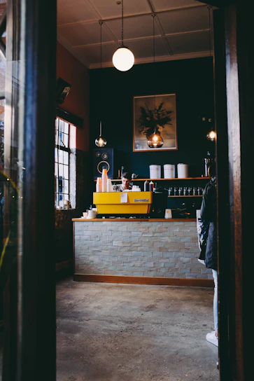 A cozy coffee shop corner filled with people chatting and enjoying steaming cups of coffee.