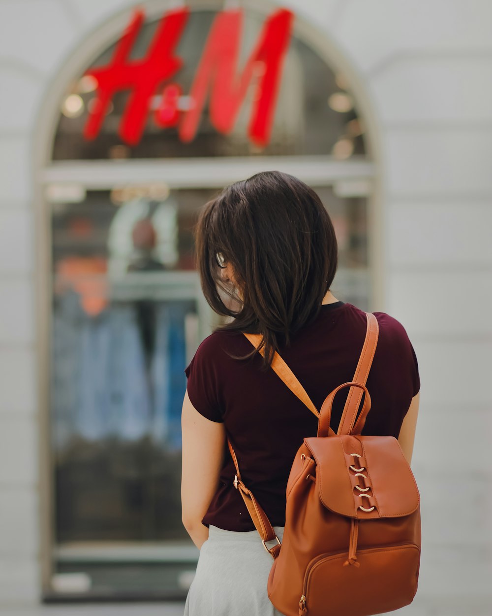 mulher enfrentando a loja H&M durante o dia